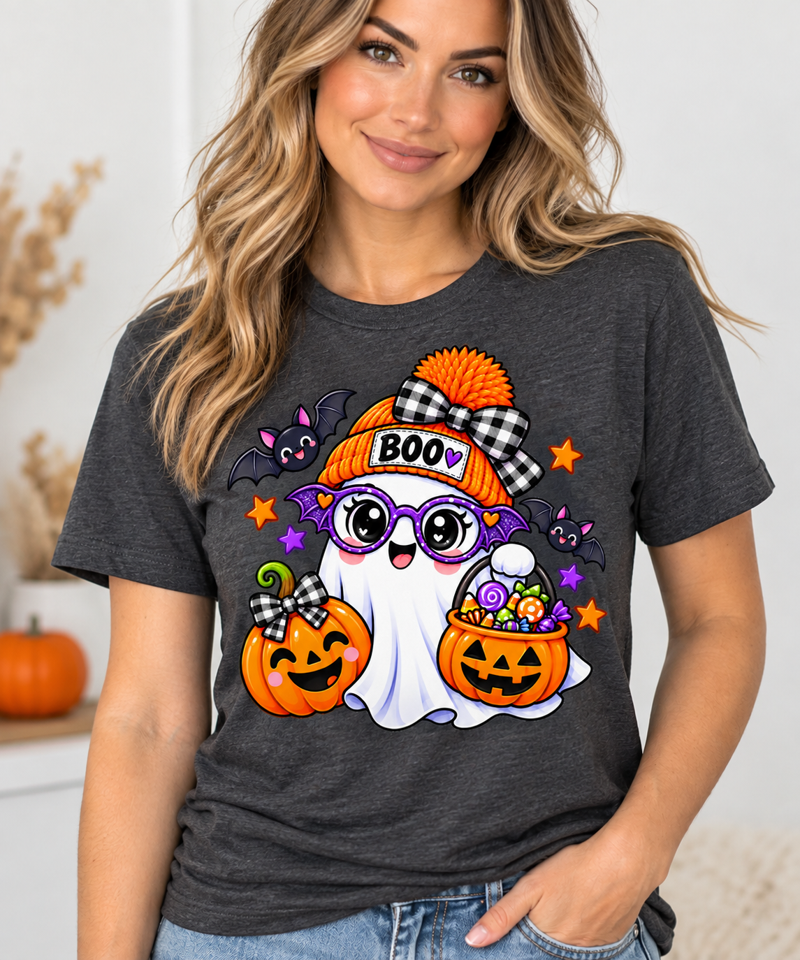 Cute white ghost wearing an orange BOO beanie and purple bat glasses, with smiling jack-o'-lantern pumpkins, candy, and bats, on a toddler Halloween t-shirt