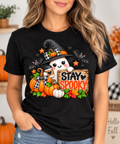 Woman wearing a black t-shirt with Stay Spooky ghost witch Halloween graphic featuring pumpkins and bats