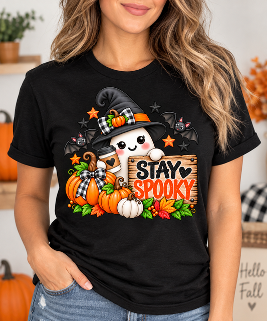 Woman wearing a black t-shirt with Stay Spooky ghost witch Halloween graphic featuring pumpkins and bats